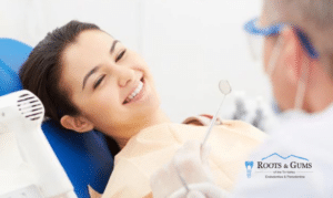 Woman receiving dental examination from dentist in clinical setting, smiling during treatment.